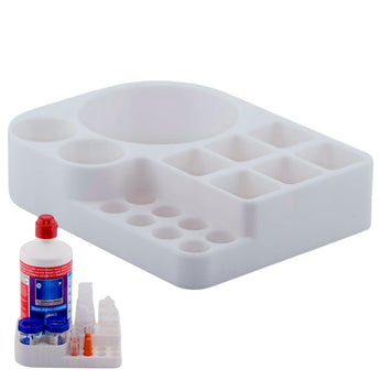 A white scleral lens care station organized holder with various compartments, shown alongside a bottle of Clear Care cleaning solution and single-use vials.