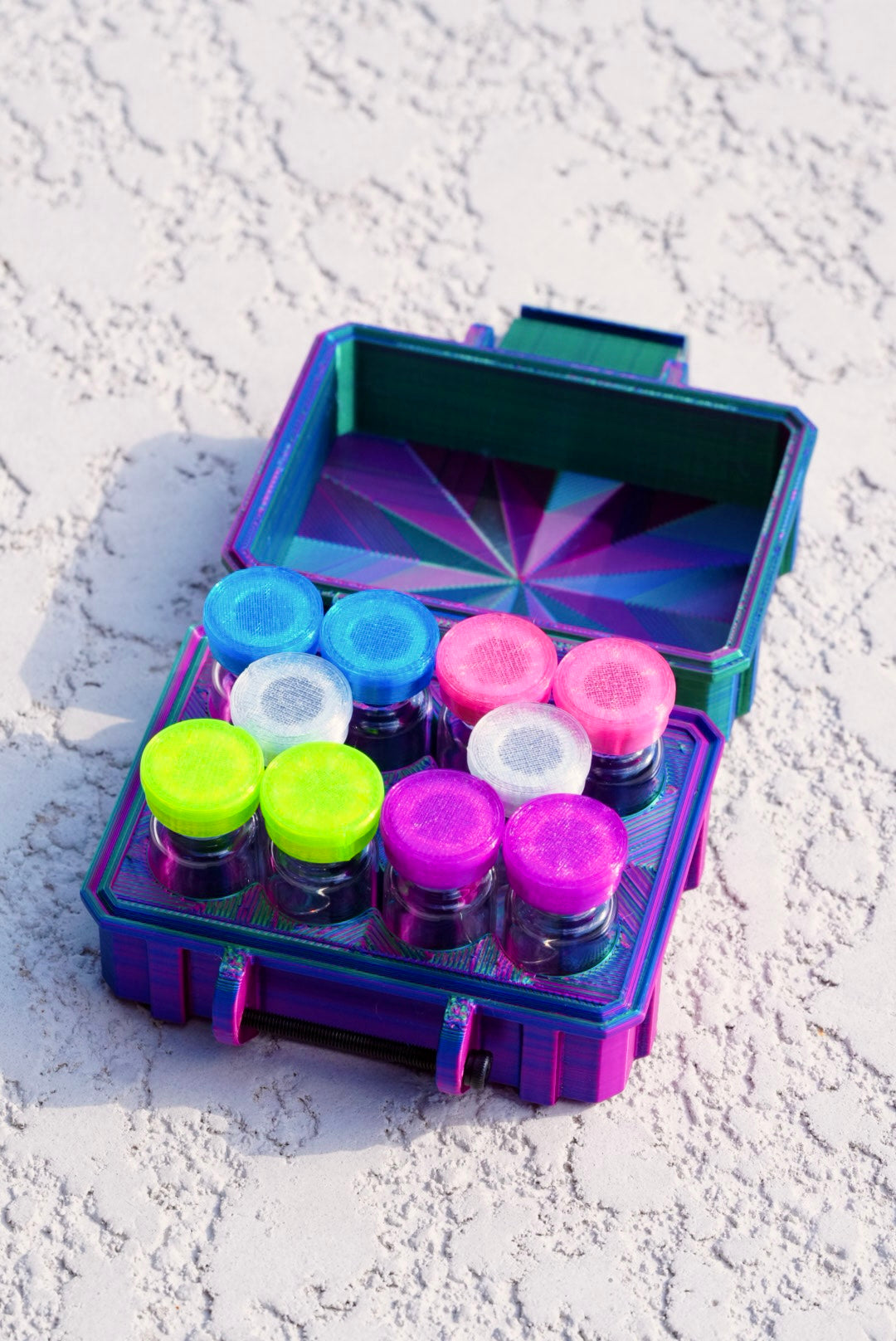Colorful vial case box with various lids on a textured white surface