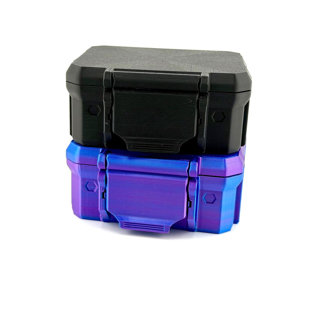 Closed black 3D-printed hard storage case stacked on top of a closed iridescent blue and purple case.