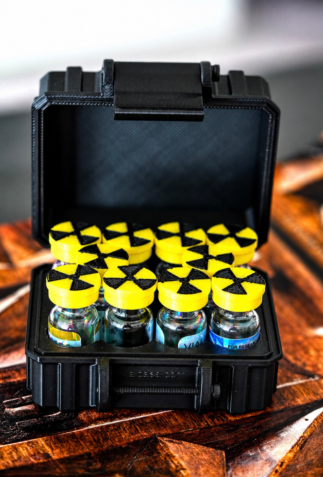 Radio Yellow flexible vial caps with a radiation symbol on 3 mL vials in a black case