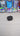 Black rectangular object with a stand on a white background

