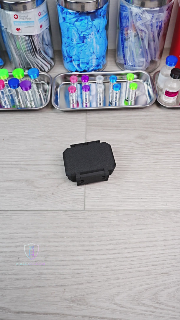 Black rectangular object with a stand on a white background

