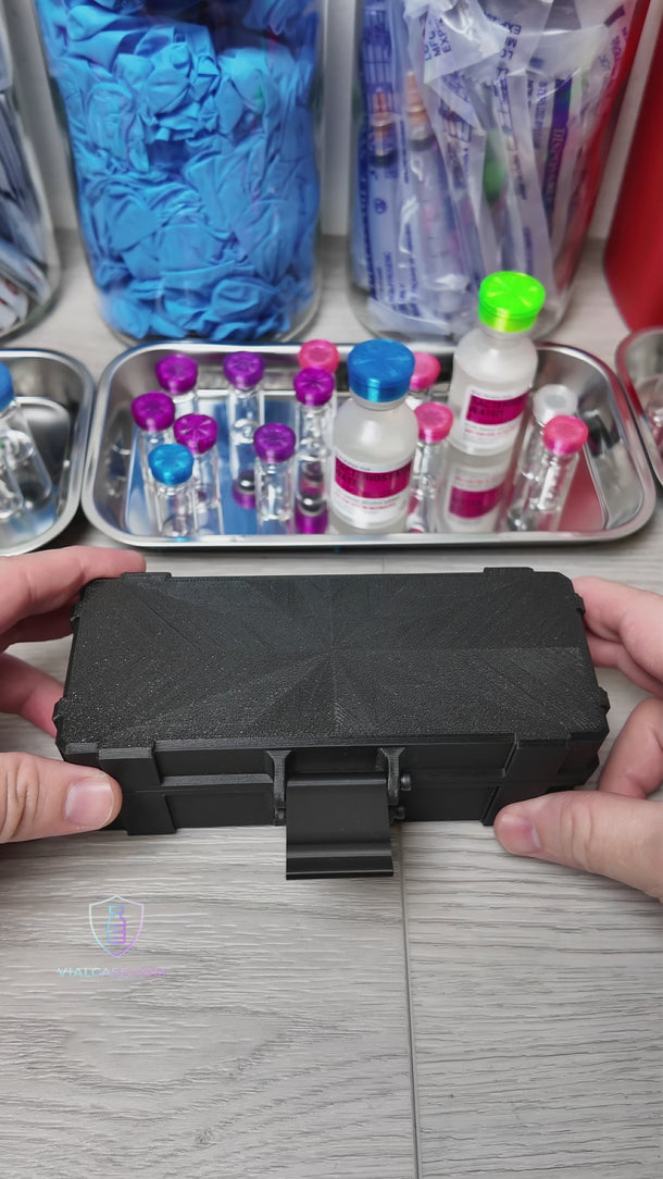 Compact hard-shell case opened to show two small vials and one larger vial arranged in separate compartments. The case is handled to demonstrate organization and portability.